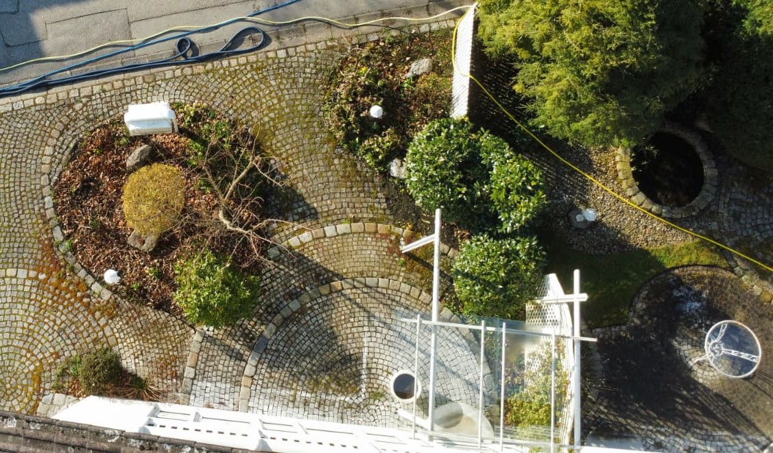 Bild von Natursteinen von oben eines Eingangsbereichs mit starker Verschmutzung durch Algen, Moos und Witterungsrückstände